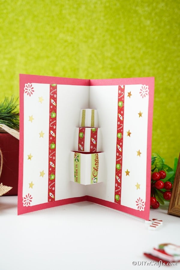 A gift box card sitting on a white counter with green background