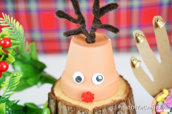 Up close picture of a single small reindeer Christmas decoration on a piece of wood