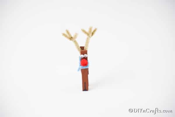 A clothespin reindeer ornament on a white surface