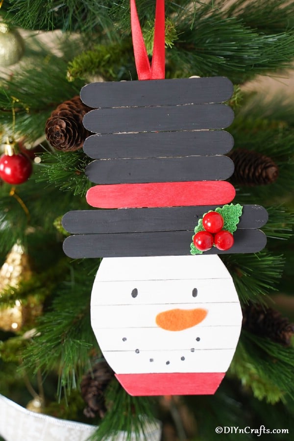Popsicle stick snowman hanging on a Christmas tree