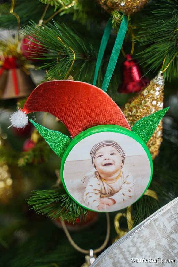 Up close picture of an elf ornament hanging on a tree