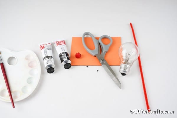 Supplies for making a light bulb penguin decoration