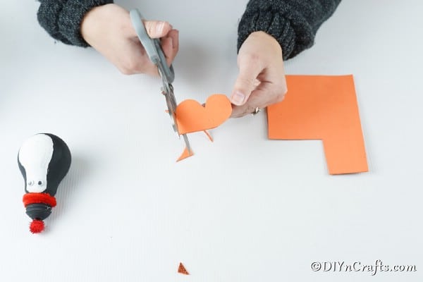 Cutting out orange feet from the penguin