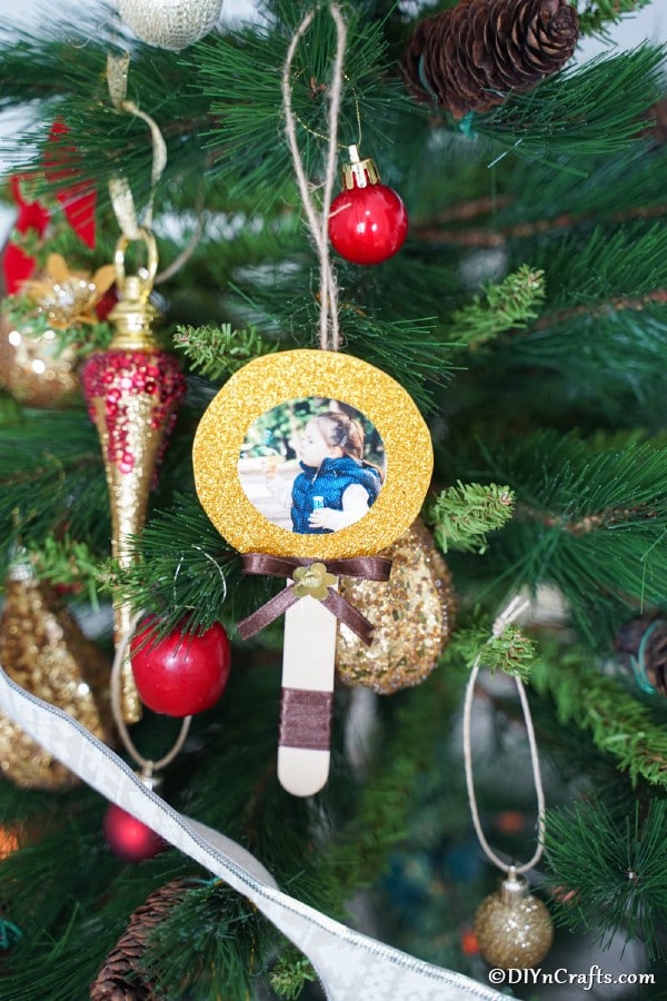Lollipop photo ornament hanging on a holiday tree