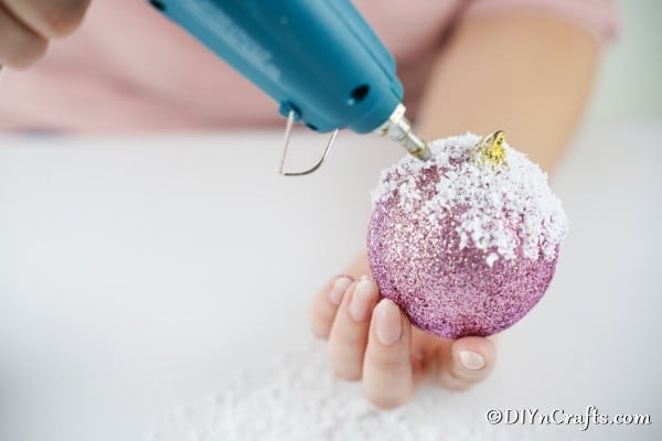 Adding more icing to a Christmas ball to make a muffin ornament
