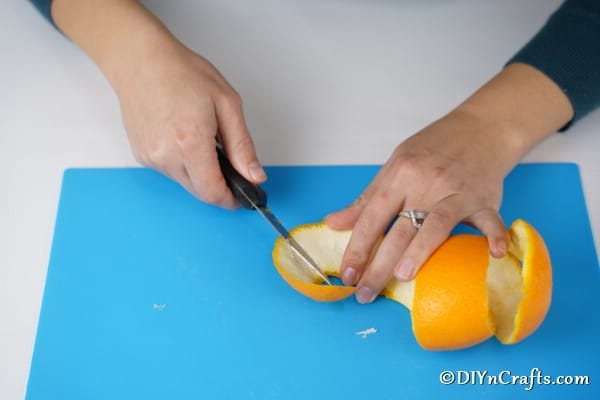 Peeling oranges to cut them into stars for garland