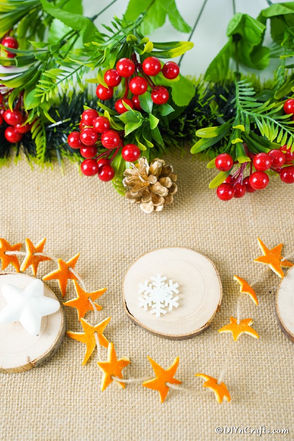 An orange star garland laying on a table with other holiday decorations