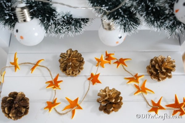 Orange peel star garland displayed on a white table with other holiday decor pieces