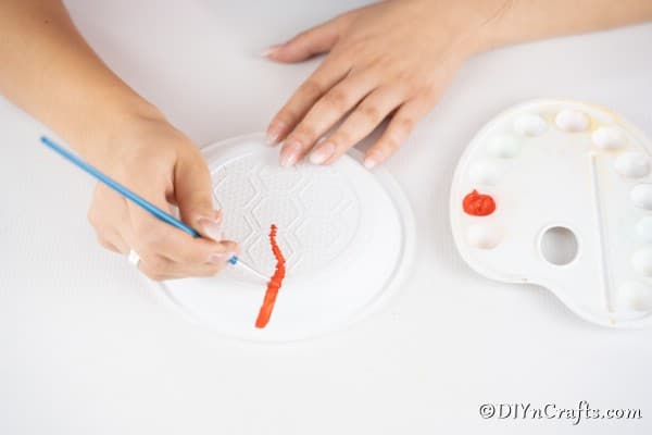 Drawing lines on the plastic plates to create a lollipop
