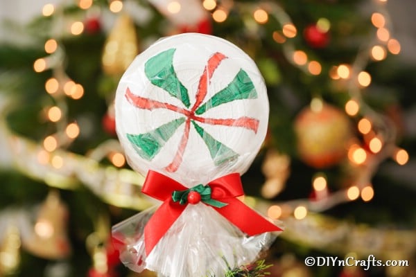 Giant lolipop displayed in front of a Christmas tree