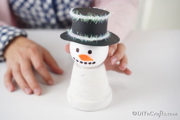 Gluing the snowman head onto the snowman decoration