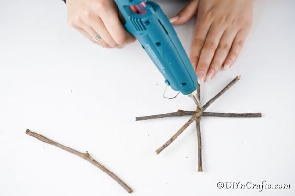 Gluing together the star ornament made from twigs