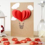A 3D hot air balloon valentine's day card on table with heart candies