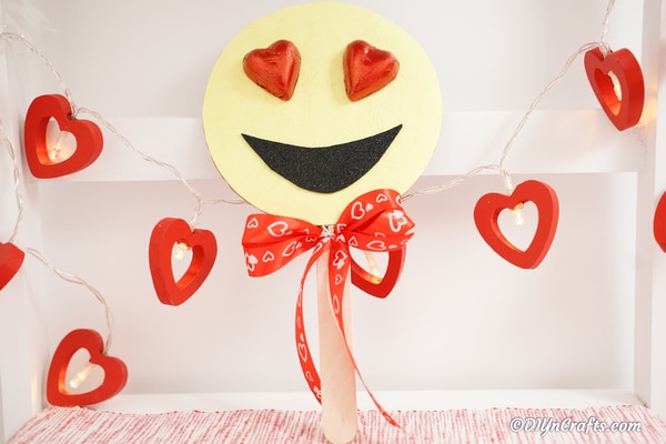 Heart smiley emoji decoration leaned against wall with heart garland