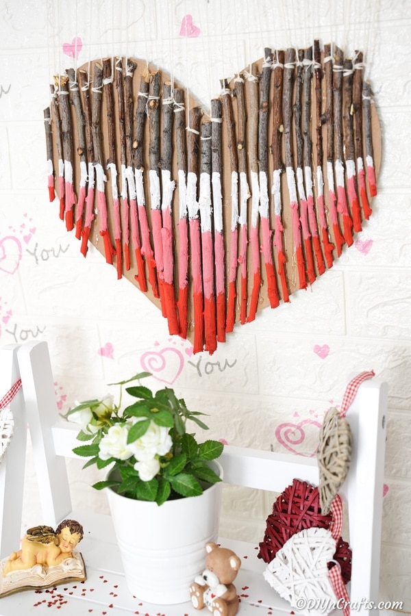 Twig painted heart wall art above white shelf