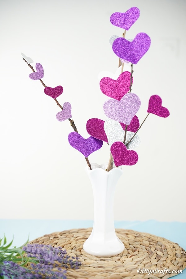White vase on woven mat filled with heart flowers