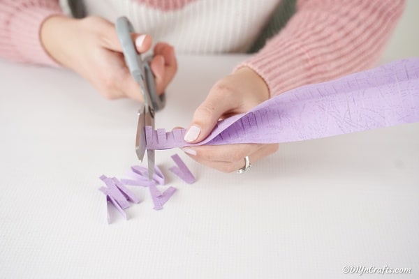 Cutting fringe on purple paper