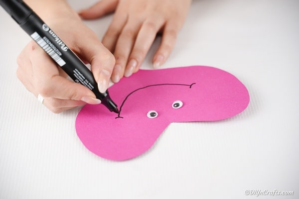 Attaching googly eyes to paper heart