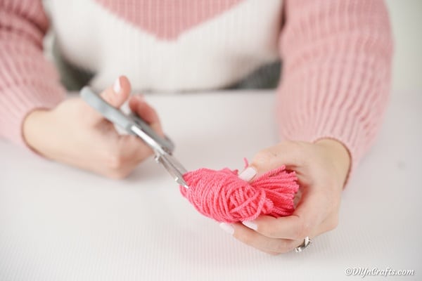 Cutting loops of yarn on pom pom monster