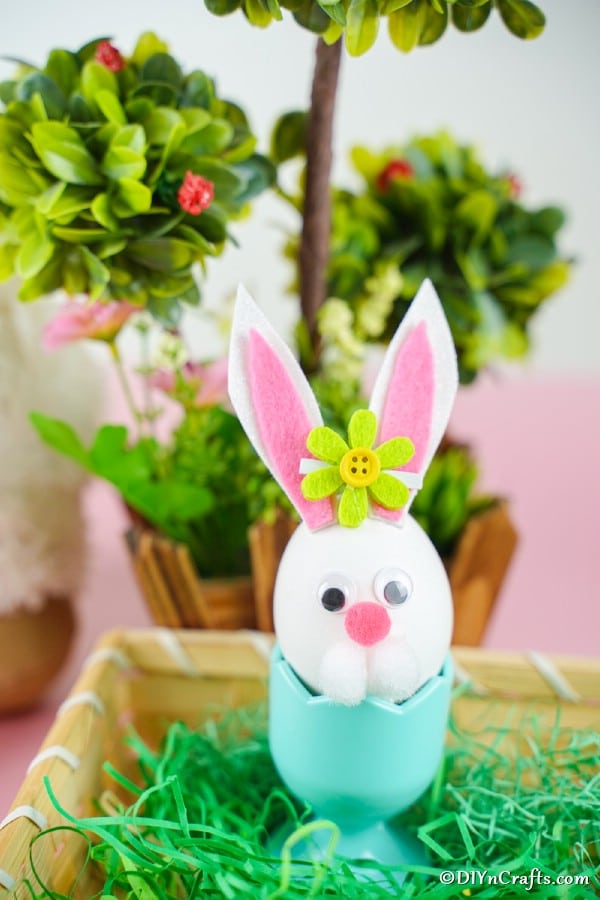 Easter egg bunny in egg cup inside easter basket
