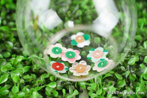 Paper button flowers in a glass jar on grass