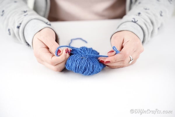 Tying string around center of yarn ball