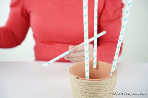 Gluing paper straws to flower pot