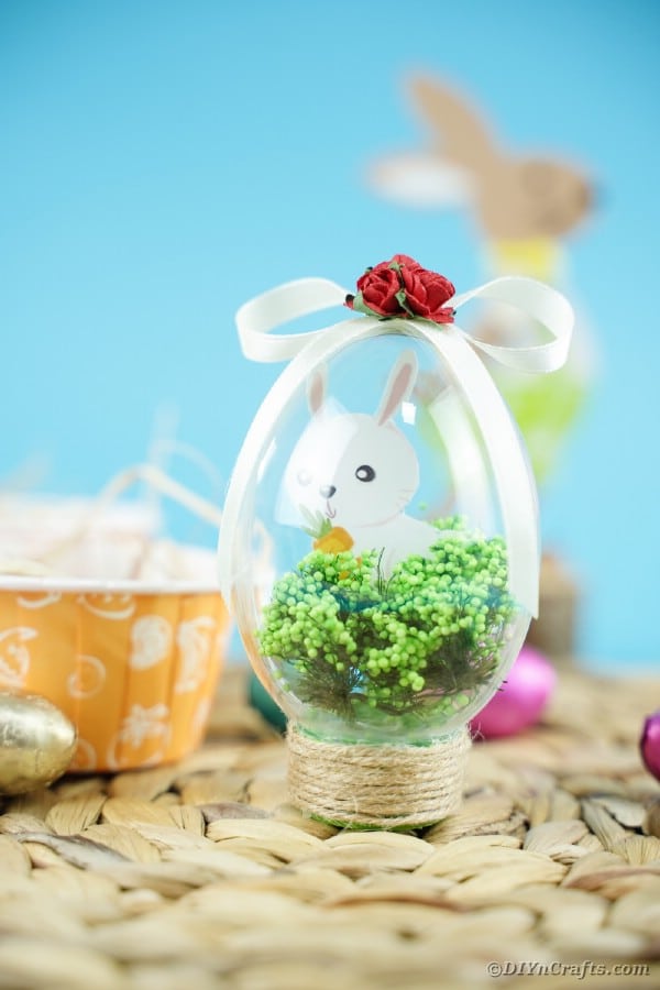 Bunny in Easter egg decoration on woven mat