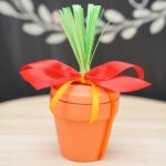Flower pot in front of chalkboard with red ribbon