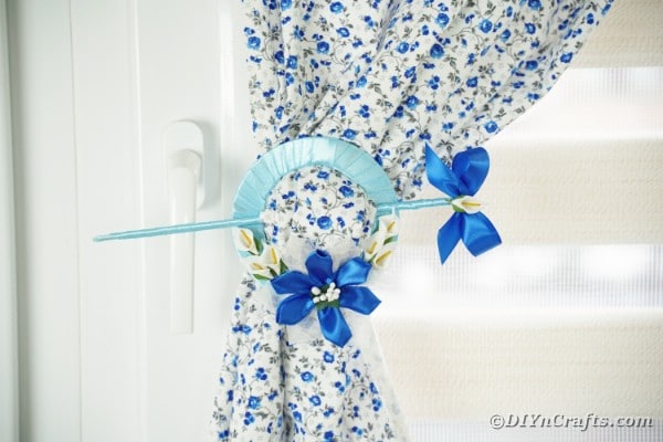 Blue cd curtain holder on blue foral cloth