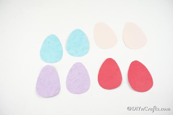 Multiple eggs in pink blue purple and red on a white surface