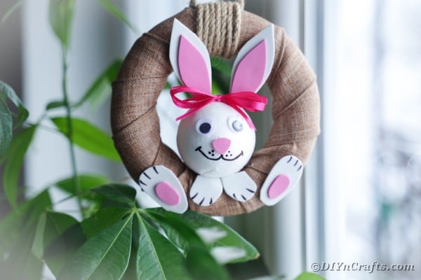 Easter bunny wreath hanging in front of plant