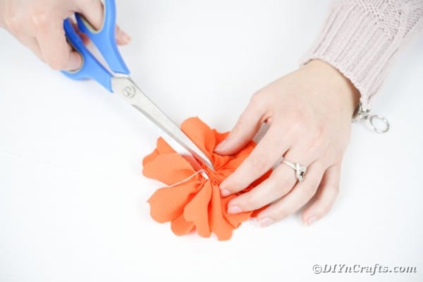 Trimming thread on orange fabric flower