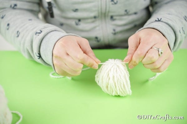 Tying yarn around middle of yarn ball
