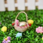 Egg carton Easter basket on grass in front of mini fence