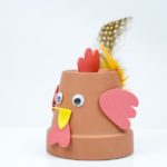Terra cotta flower pot bird with yellow feathers