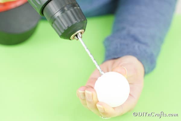 Drilling a hole through a ping pong ball