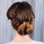 Brunette with low bun in front of grey background