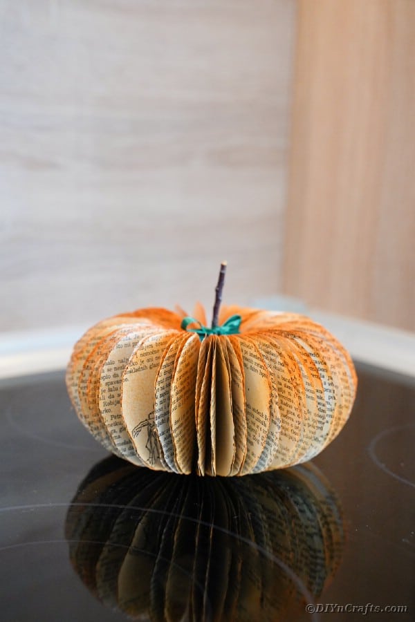 Old book page pumpkin on wooden table