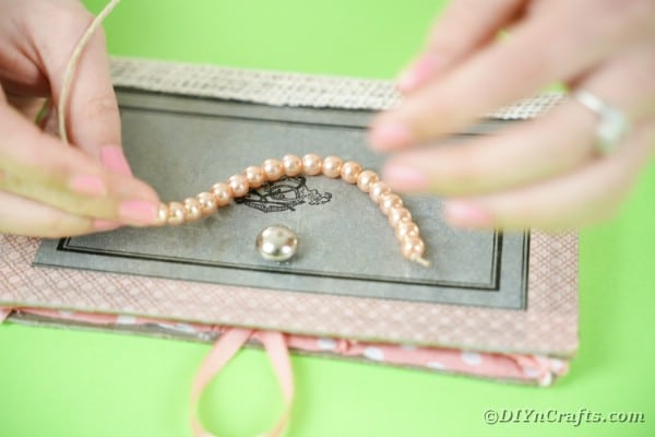 Adding beads to ribbon for purse