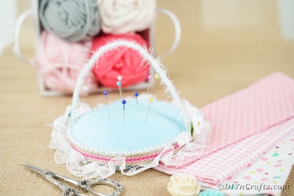 Pincushion on table with yarn