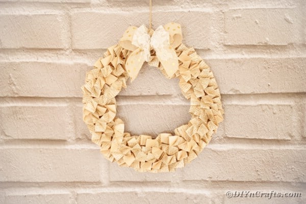 Origami paper book page wreath on brick wall