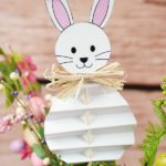 Easter bunny stuck inside plant in front of wall