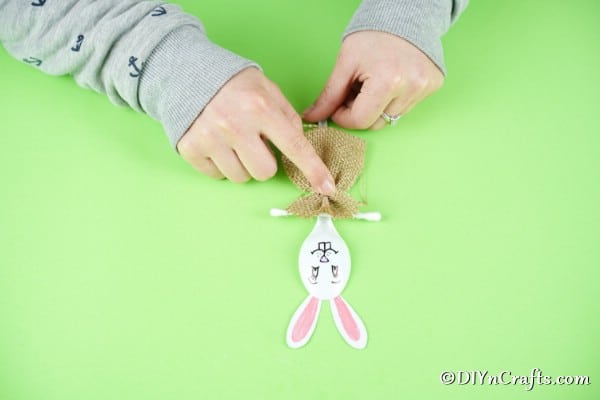 Gluing bow and q-tip onto spoon to make girl bunny