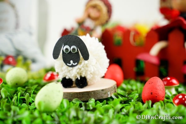 Sheep craft on fake grass and wood slice