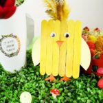 Yellow craft stick chicken next to Easter decor