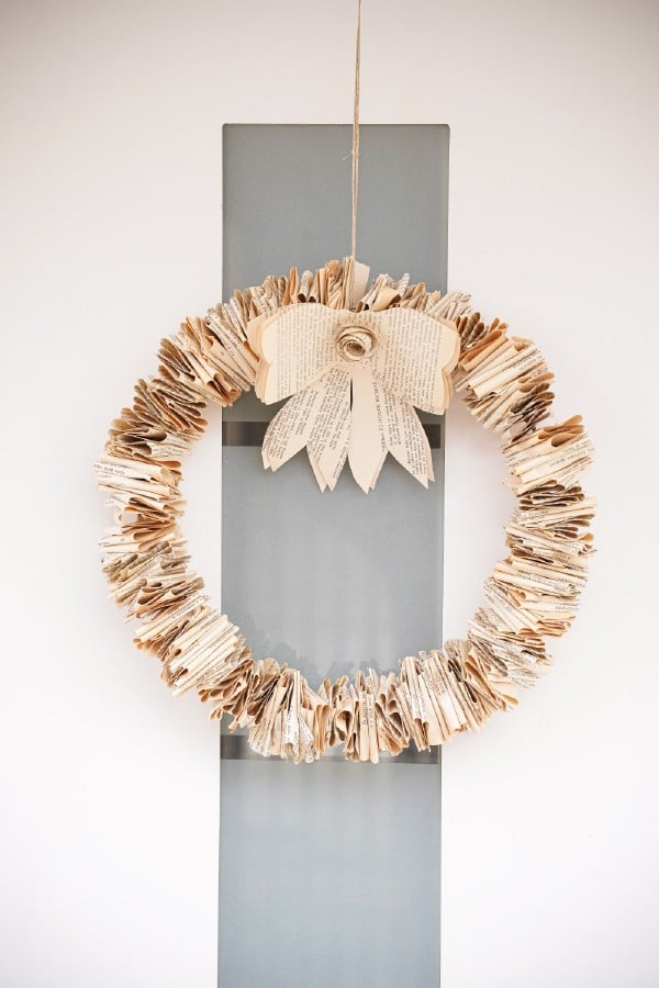 Folded book page wreath hanging on door