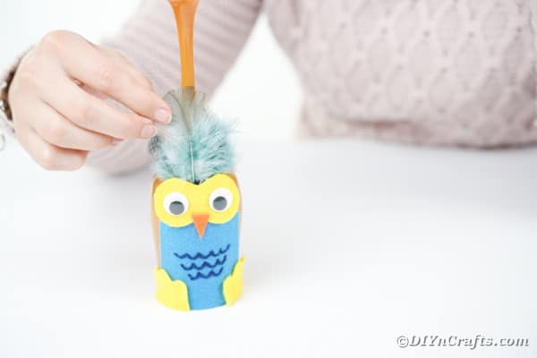 Gluing feathers to wine glass owl