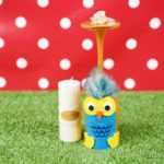 Wine glass owl on grass with red polka dot background