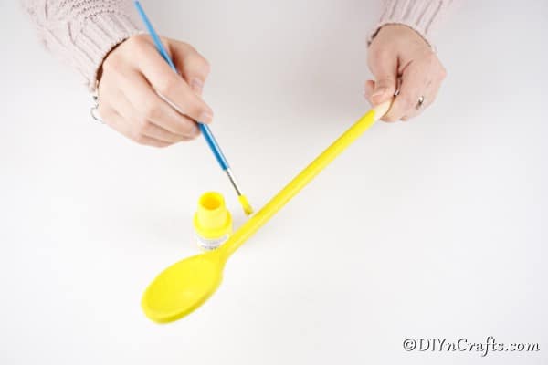 Painting wooden spoon yellow